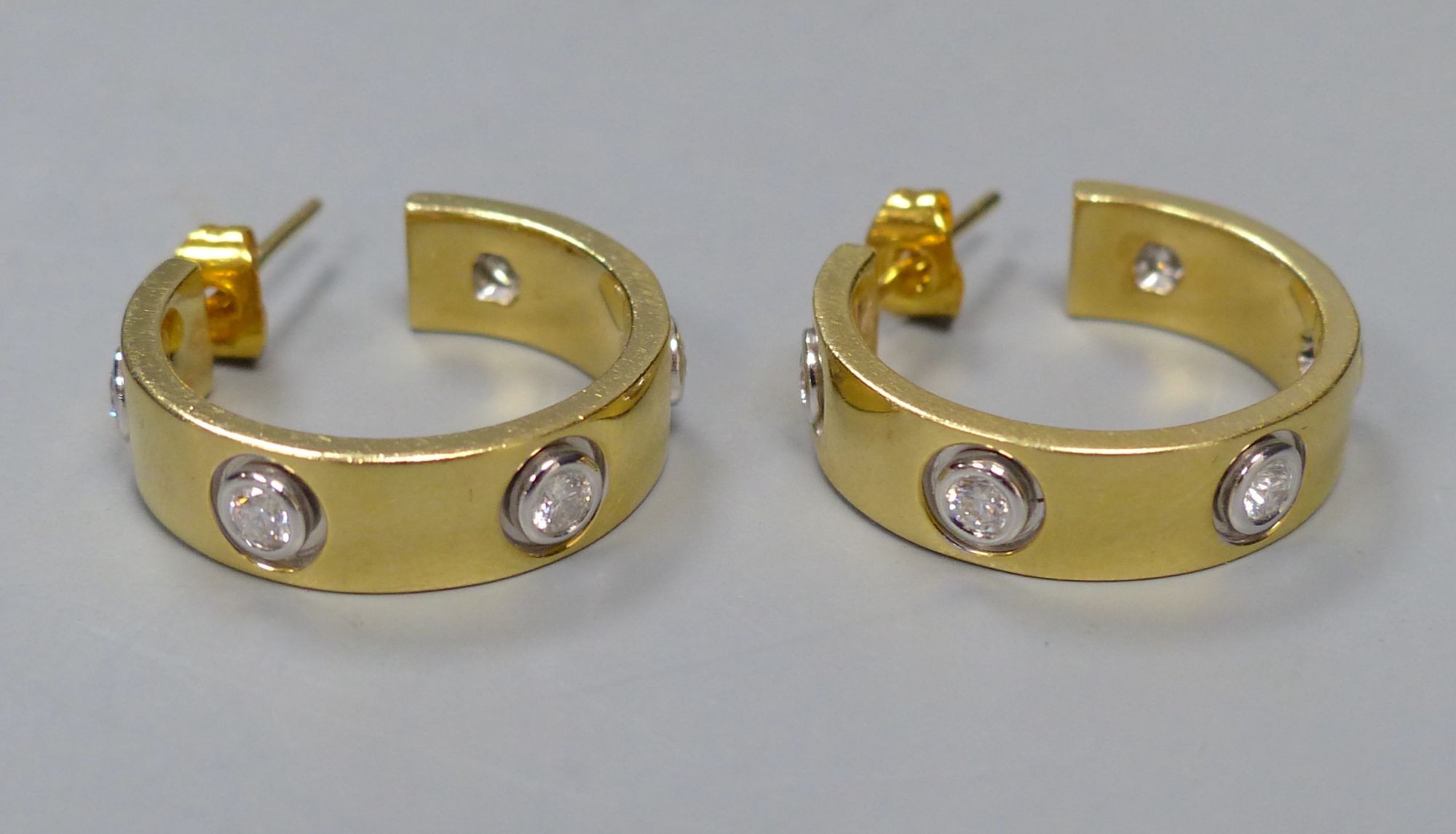 A modern pair of 18ct gold and five stone diamond set Cartier style half hoop earrings, 19mm, gross 11.2 grams.